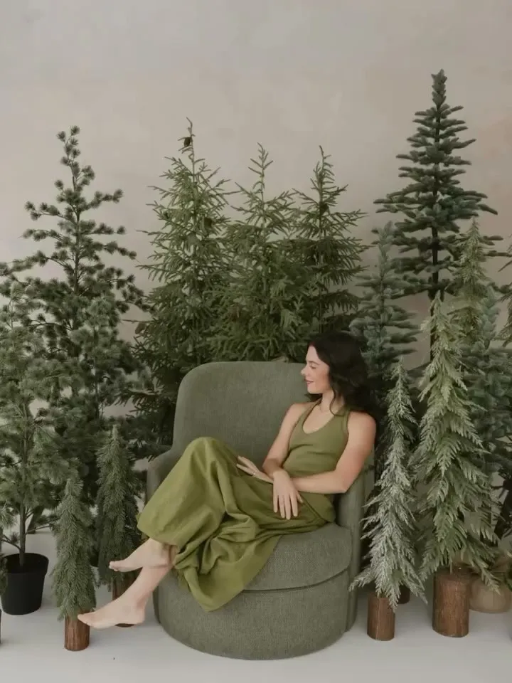 Sofía sentada en un sillón verde entre los pinos